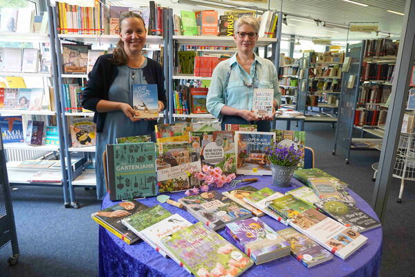 Stefanie Kron (links) und Gabriele Linden präsentieren eine Auswahl an Gartenbüchern, die in der Stadtbücherei zu finden sind.