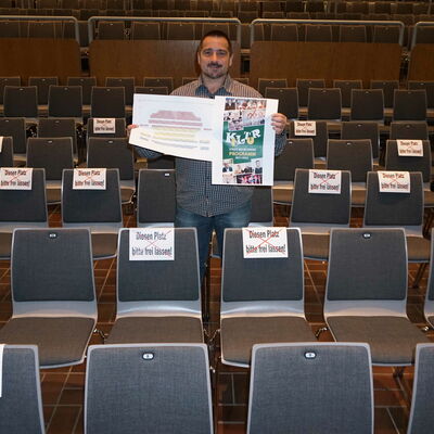 Marco Marcegaglia zeigt, wie es geht: Neben zwei besetzten Plätzen kommen zwei leere Stühle.