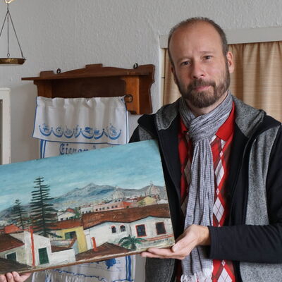 Das Gemälde, das Thorsten Prinz in den Händen hält, zeigt die Stadtansicht von Palermo. Das Motiv hat Josef Horn mehrmals gemalt, so Dokumentationen.