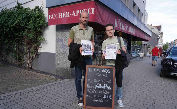 Thorsten Prinz (links) und Noel Schröder vor der Buchhandlung Appelt, die offensiv für den Kulturpass Werbung macht.